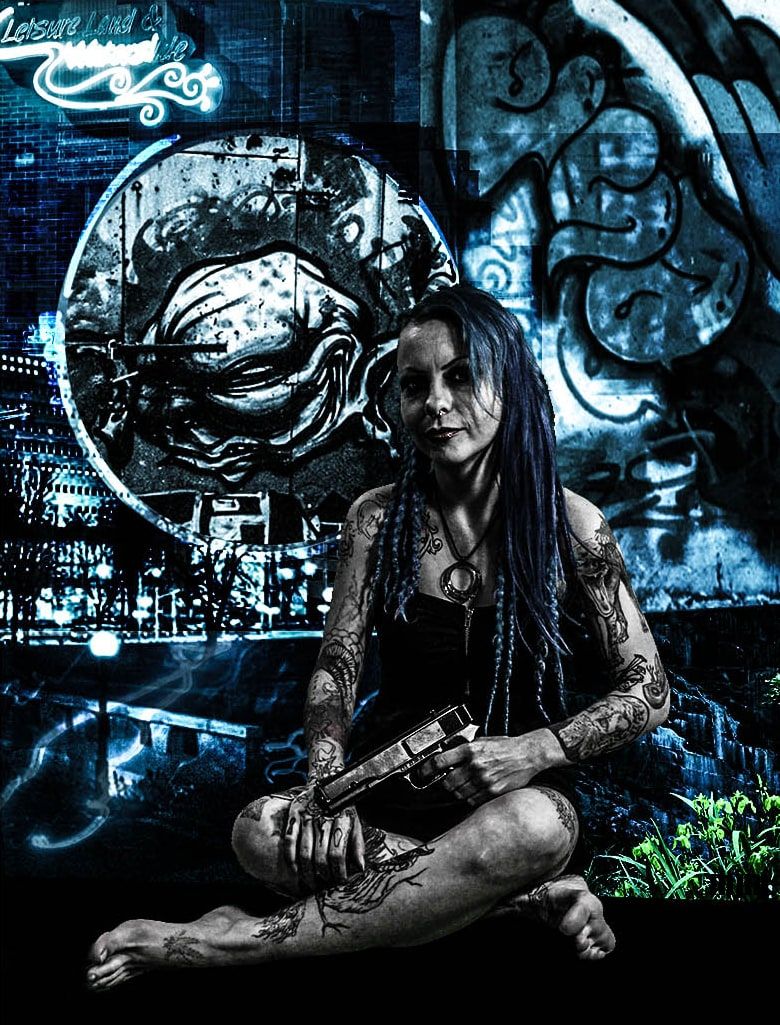 Tattooed woman with long blue-black braids sits cross-legged holding a pistol in front of graffiti, a blue-toned cityscape and a neon sign.
